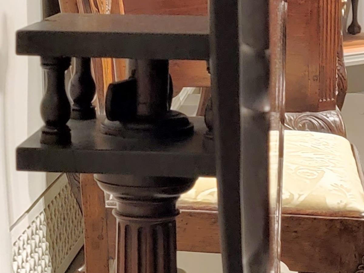 Underside close-up of an antique tilt-top table birdcage mechanism with turned balusters wooden locking wedge and vertical tilted tabletop